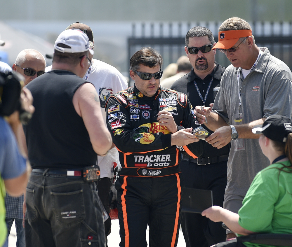 NASCAR driver Tony Stewart signs autographs as he makes his way to his car to practice for Sunday’s race at Atlanta Motor Speedway in Hampton, Ga., on Friday.