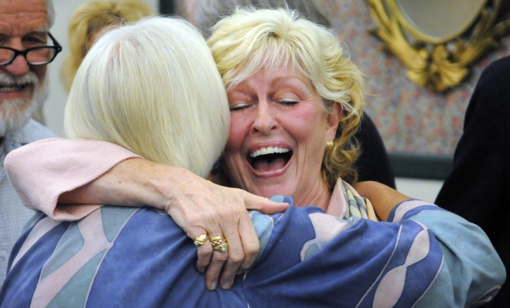 Gilda Nardone, executive director of Women, Work and Community, left, hugs University of Maine at Augusta President  Allyson Handley after the announcement of the plan to give the Gannett Building on Water Street in Augusta a new name — Handley Hall. Nardone’s group has offices on top floor of the downtown building.