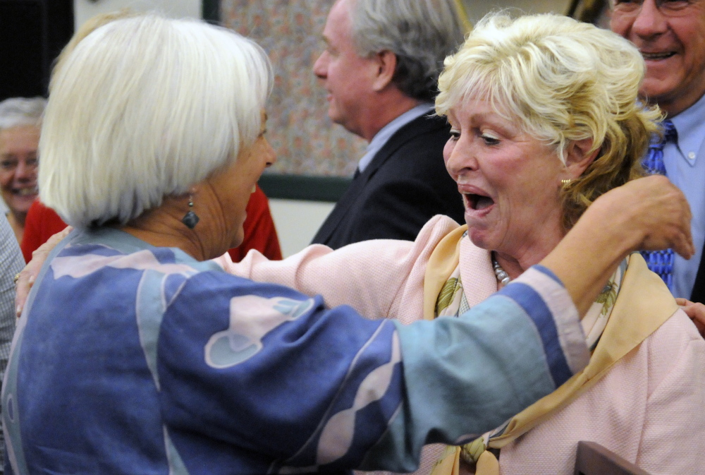 Gilda Nardone, executive director of Women, Work and Community, left, hugs University of Maine at Augusta president  Allyson Handley after the announcement of the plan to change the name of the Gannett Building on Water Street in Augusta to Handley Hall.