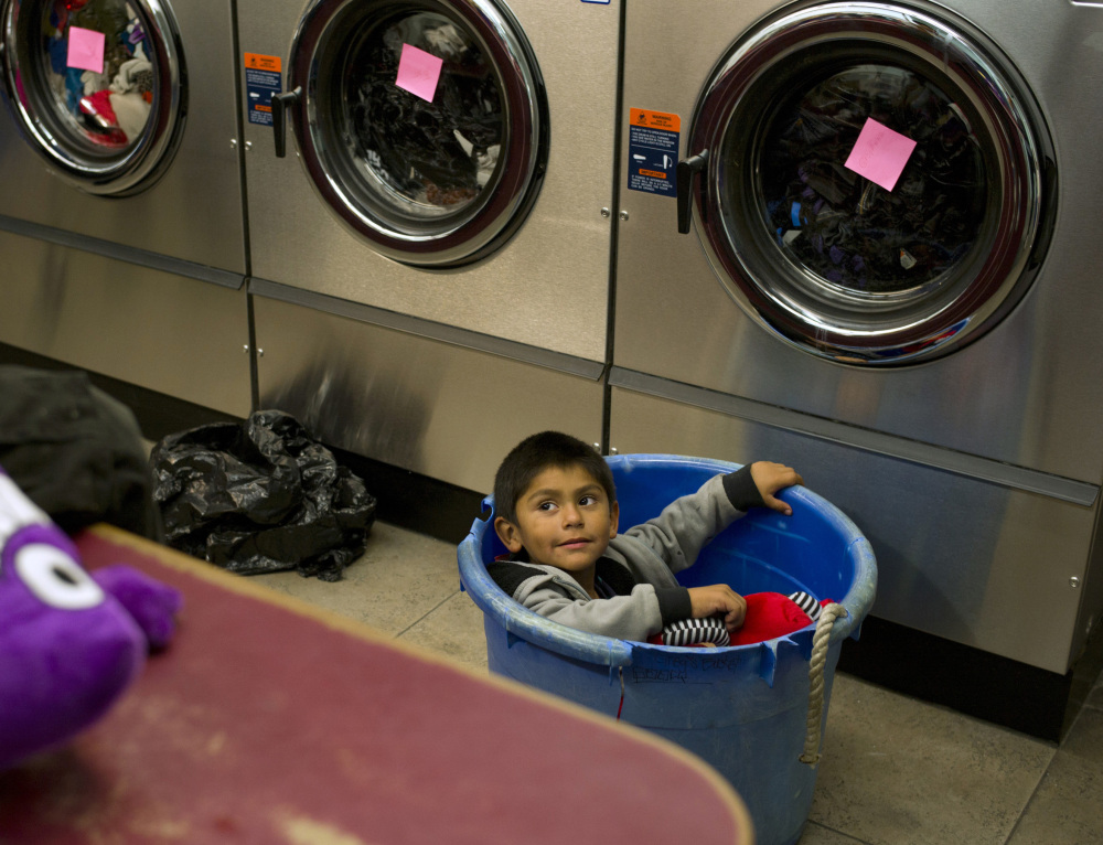  Jose Cortez, 4, sits in a laundry basket while waiting for his mother to finish their laundry.