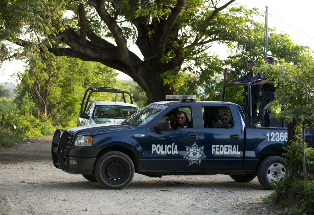 Federal police and immigration vehicles patrol near the railroad tracks as a northbound freight train departs from Arriaga, Mexico. A crackdown seems to be keeping women and children off the train, known as “The Beast.”