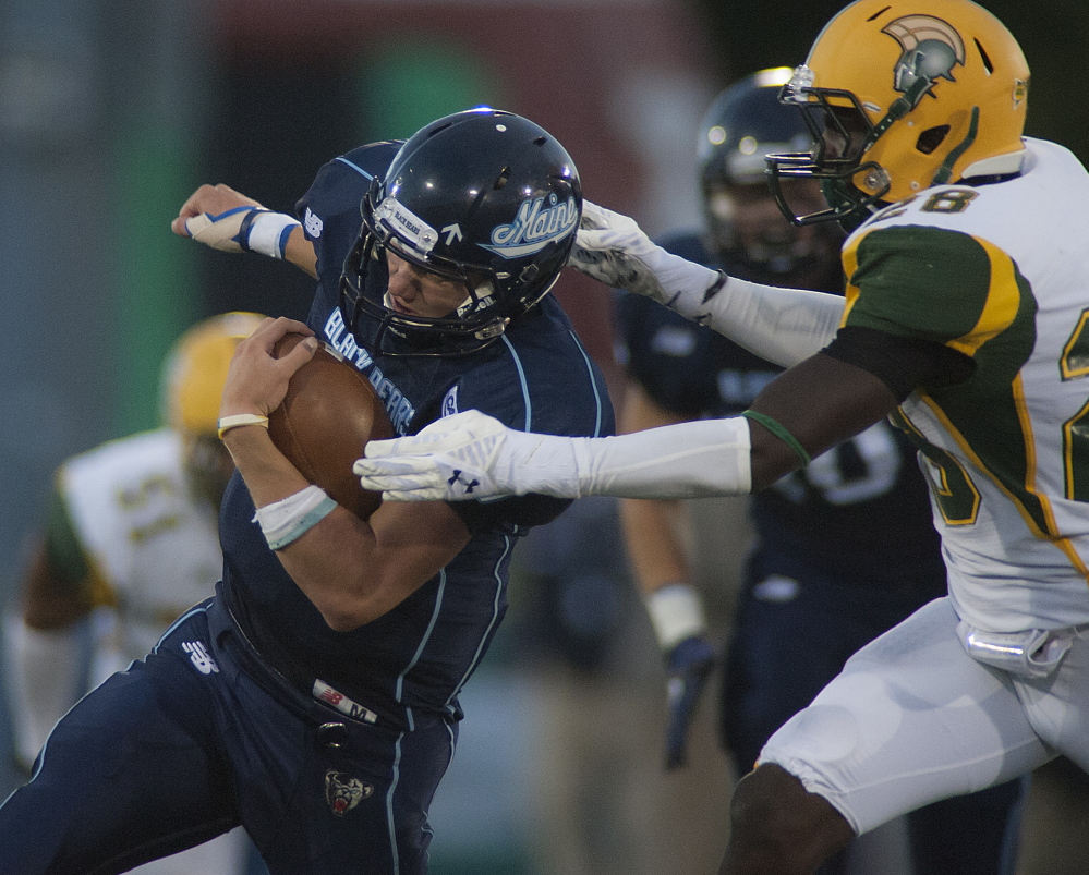Maine quarterback Dan Collins attempts to slip past Troi Hughes of Norfolk State in the first half of Maine’s 10-6 victory Saturday night in a mutual opener at Alfond Stadium.