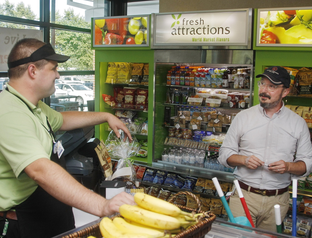 Comedian John Hodgman, right, visits Jonathan ‘Banana Man’ Niederer at the Kennebunk service plaza Saturday. Hodgman says Niederer’s pitch has a traditional ring.
