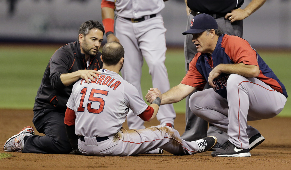 Boston Red Sox second baseman Dustin Pedroia, center, is helped by manager John Farrell, right, and a trainer after suffering an injury in a collision with Tampa Bay Rays' Logan Forsythe at second during the second inning Saturday in St. Petersburg, Fla. Pedroia left the game. The Associated Press