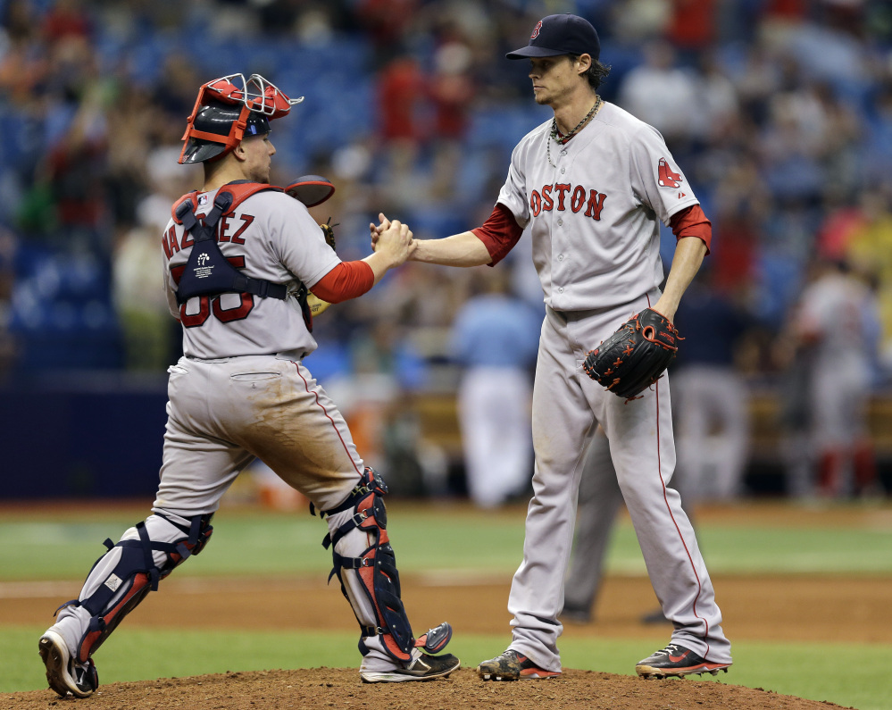 Boston Red Sox starting pitcher Clay Buchholz, right, shakes hands with catcher Christian Vazquez after throwing a complete game shutout against the Tampa Bay Rays Sunday in St. Petersburg, Fla.
