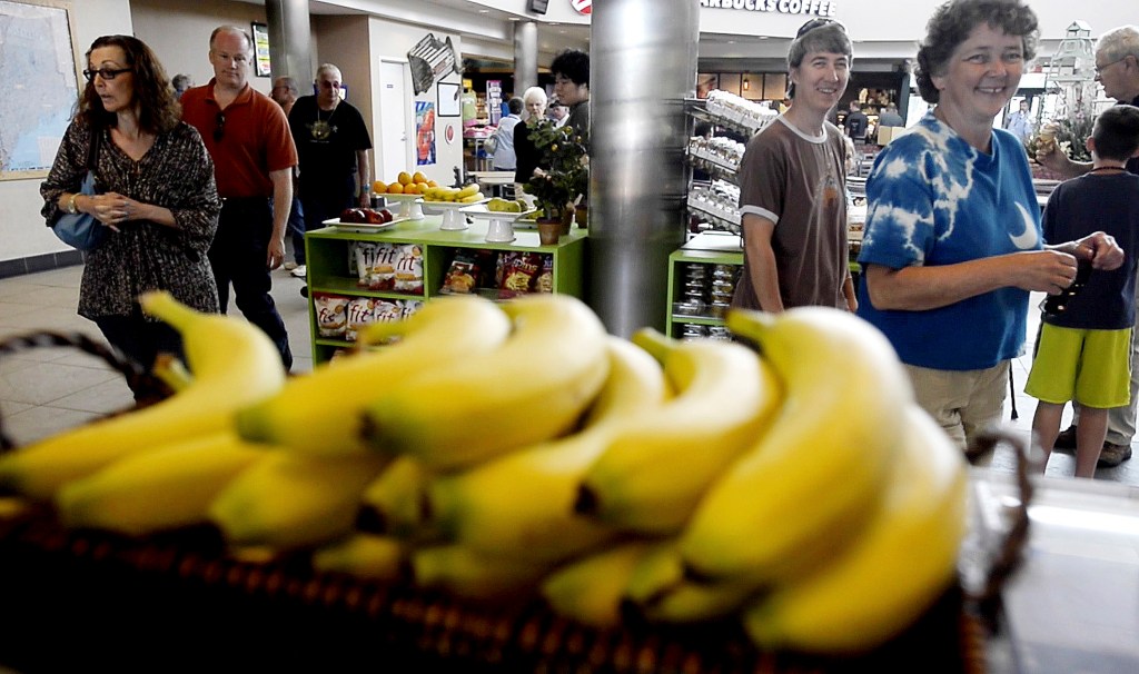 Market customers react to Jonathan Niederer as he sells bananas. Shawn Patrick Ouellette/Staff Photographer