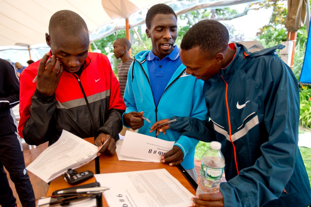 Three of the Beach to Beacon’s expected front runners, from left, Stephen Kosgei Kibet, Emmanuel Bett and Bedan Karoki – all of Kenya – fill out the paperwork and get their bibs Friday for Saturday’s big race. Gabe Souza/Staff Photographer