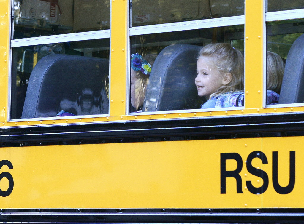 First grade student Elizabeth Baker is all smiles as she joins other RSU 14 students in Windham on the bus for the first day of school. John Patriquin/Staff Photographer