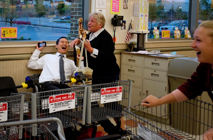Edward Foye, a grocery clerk at the Market Basket in Biddeford, laughs as Joanne Twomey, former mayor of Biddeford, runs into the store around 7:15 p.m. Friday to celebrate the indications that Arthur T. Demoulas was going to buy the company. At right is employee Jackie Murphy. Nothing will be made official until the board meets to discuss the bids. Gabe Souza/Staff Photographer