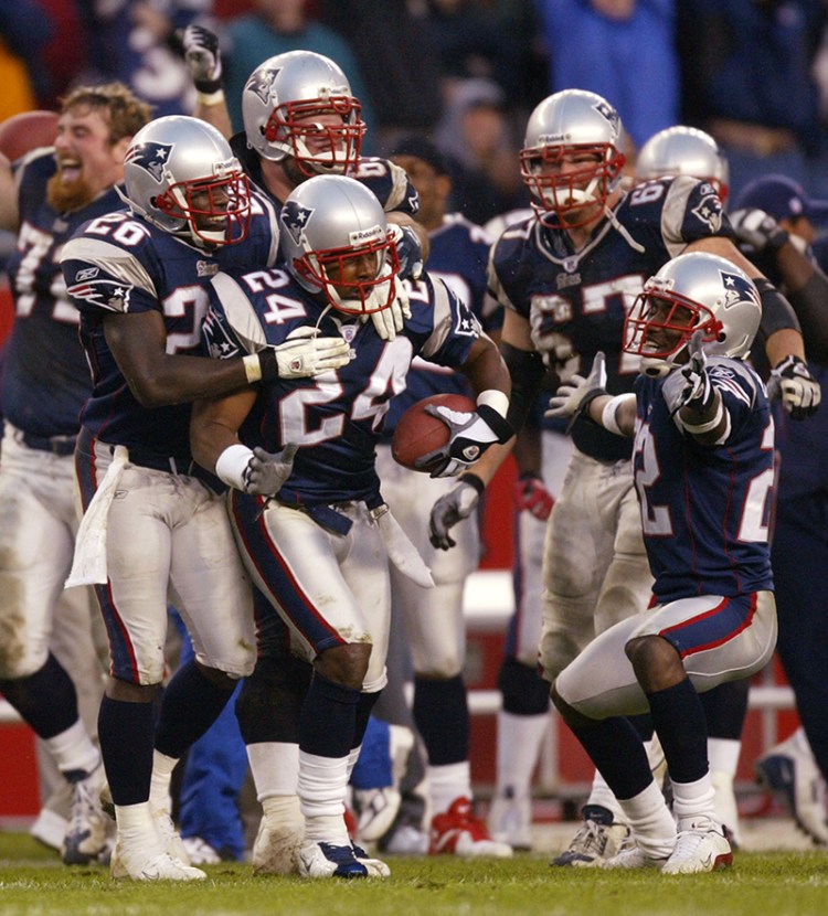 In this file photo, New England Patriots' Ty Law (24) is congratulated by teammates Eugene Wilson (26) and Asante Samuel, right, after Law's interception late in the fourth quarter sealed a 9-3 win over the Cleveland Browns at Gillette Stadium in Foxboro, Mass., Oct. 26, 2003. The Associated Press