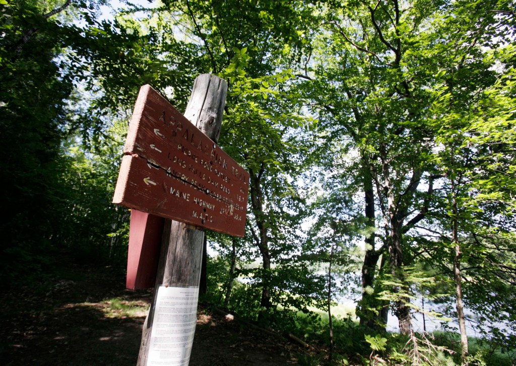 A sign directs hikers to nearby points of interest near the Kennebec River in Carrying Place Township, Maine, along the Appalachian Trail.