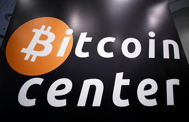 A sign for the Bitcoin Center New York City, located in the city's financial district, is displayed at the Inside Bitcoins conference and trade show, April 7, 2014 in New York. The Associated Press