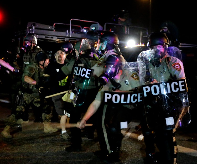 A man is detained after a standoff between protesters and police Monday night during a protest for Michael Brown, who was killed by a police officer Aug. 9 in Ferguson, Mo. Brown's shooting has sparked more than a week of protests, riots and looting in the St. Louis suburb.