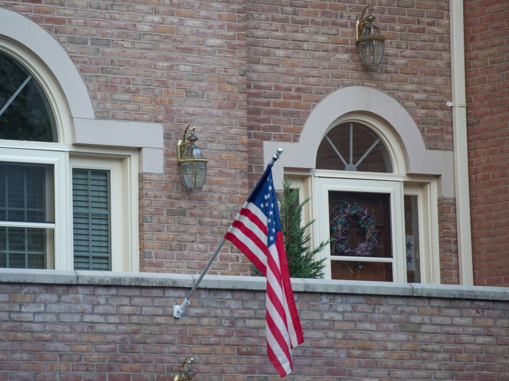 An American flag hangs above the front door of the home of Maj. Gen. Harold Greene in Falls Church, Va., Tuesday. The Associated Press