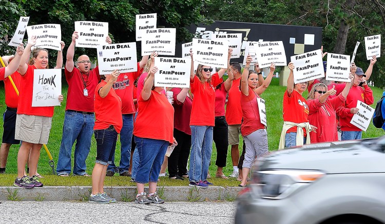 FairPoint employees, members of IBEW and CWA unions, react to honking horns of support as they picket at  the corner of Riverside and Davis Farm Road in Portland Tuesday. Gordon Chibroski / Staff Photographer