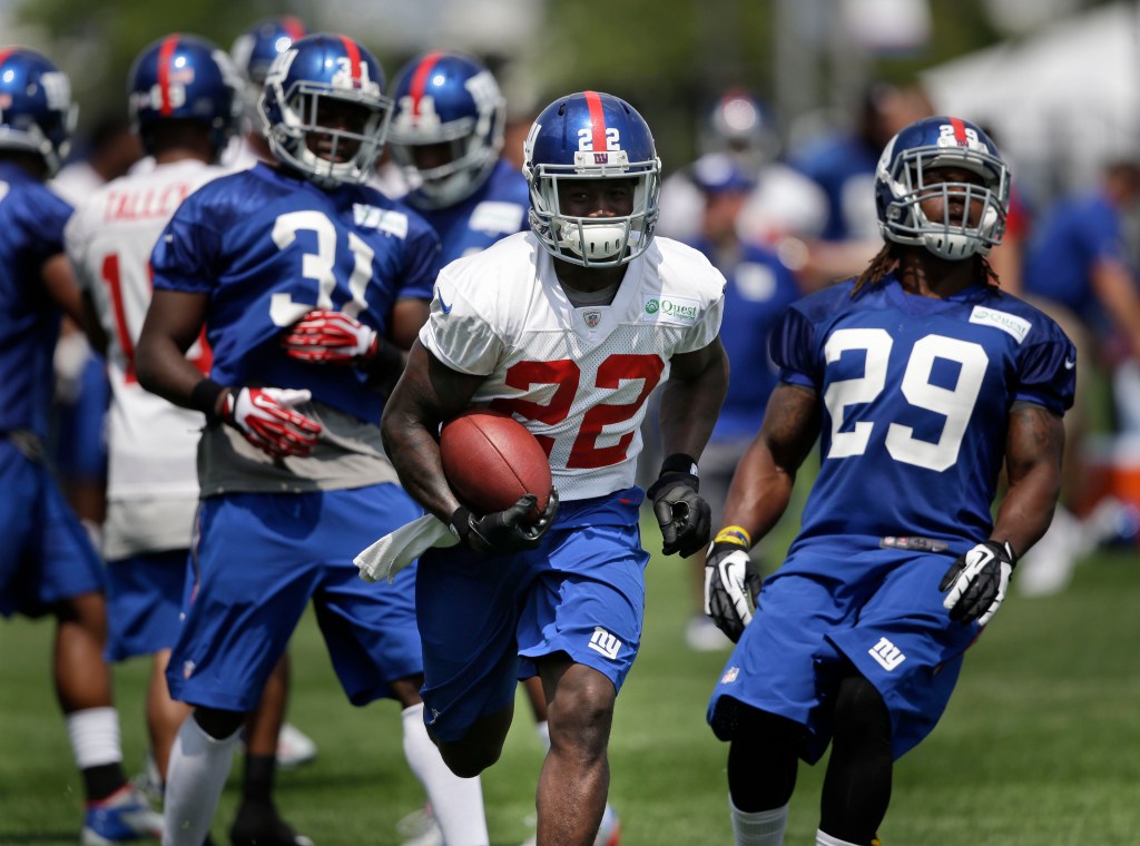 New York Giants running back David Wilson, seen running with the ball at training camp on July 22, said Monday that he will stop playing because of a back injury.