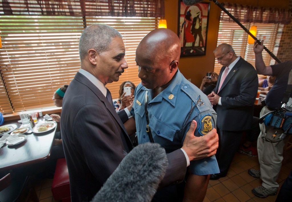 Attorney General Eric Holder greets Capt. Ron Johnson of the Missouri State Highway Patrol at Drake's Place Restaurant in Ferguson, Mo., on Wednesday.