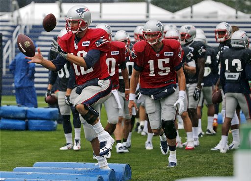 New England Patriots quarterback Tom Brady, left, catches a football as he leads Ryan Mallett (15) and others in a drill during a training camp joint practice of the New England Patriots and the Philadelphia Eagles in Foxborough, Mass., on Wednesday. The Associated Press