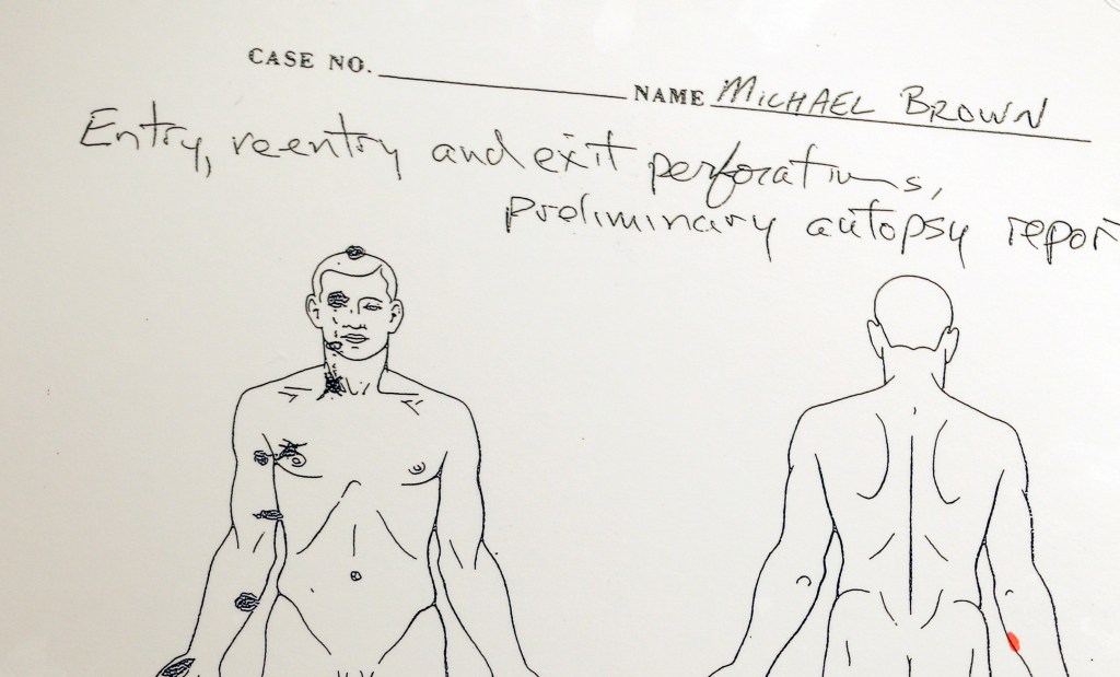 A diagram is shown during a news conference held to share preliminary results of a second autopsy done on Michael Brown on Monday in St. Louis County, Mo. The independent autopsy shows 18-year-old Michael Brown was shot at least six times.