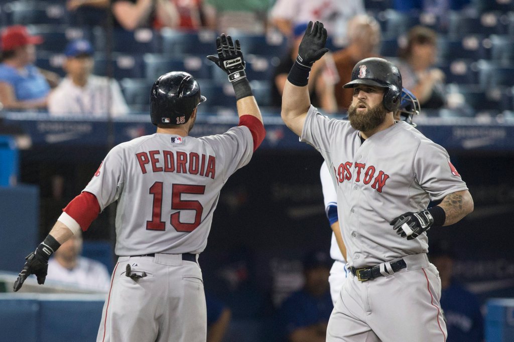 Boston Red Sox's Mike Napoli, right, is congratulated by Dustin Pedroia after hitting a three-run homer off Toronto Blue Jays pitcher Sergio Santos during the 11th inning of a baseball game Tuesday in Toronto. 