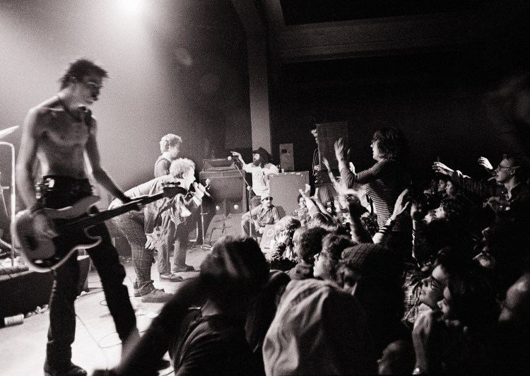 The Sex Pistols get a form of audience participation in Memphis, Tenn., in this Jan. 7, 1978, photo.  At left is bass player Sid Vicious. Group leader Johnny Rotten crouches next to him. The Associated Press