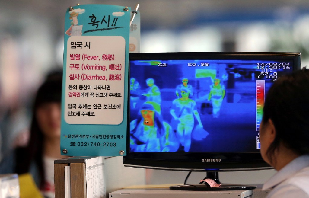 In South Korea, a quarantine officer at the Incheon International Airport checks a thermal camera showing the body temperature of passengers arriving from West Africa and other areas affected by the deadly Ebola virus. The Associated Press