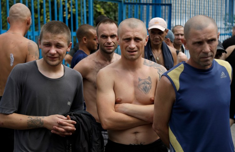 Inmates stand in a yard at a high-security facility in Donetsk, eastern Ukraine, on Monday. Authorities say more than 100 prisoners fled from the facility after it was hit by shelling. The Associated Press