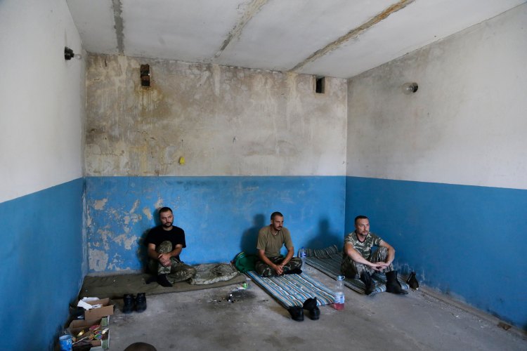 Captured Ukrainian border guards sit in a garage at the Novoazovsk border crossing point, in eastern Ukraine Friday. Novoazovsk fell swiftly to the rebels Wednesday after being pounded by shelling. The Associated Press