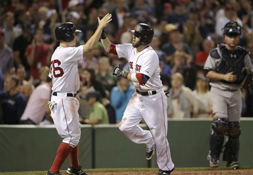 Red Sox second baseman Dustin Pedroia is welcomed home by Brock Holt after hitting a two-run home run in the second inning against the Yankees on Sunday. The Associated Press