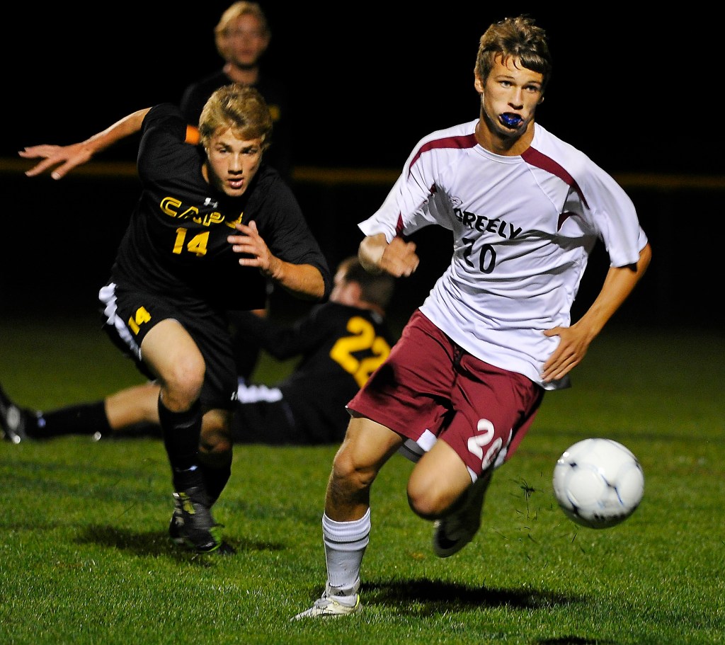 Ben Leverett of Greely dribbles the ball into the Cape Elizabeth end Tuesday night while pursued by Connor Thoreck during Greely’s 2-1 victory. The Rangers took a 2-0 lead, then had to withstand a Cape Elizabeth flurry over the final 20 minutes. Gordon Chibroski/Staff Photographer