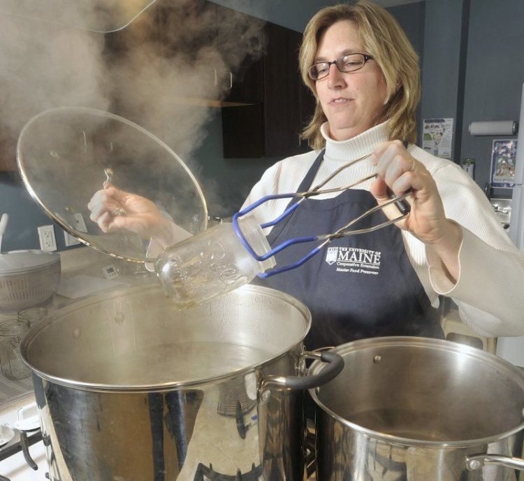 Kathleen Savoie removes a sterilized canning jar from boiling water at the University of Maine's Cooperative Extension in Falmouth last March. Jarden, the country's largest manufacturer of canning jars and lids, has recently changed its recommendations for water-bath canning procedures, saying that the jars do not have to be sterilized before use.