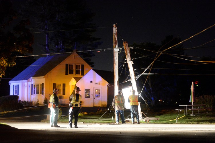Workers check a utility pole that snapped in half Thursday night on Millbrook Road in Scarborough, near Route 1, and dropped wires onto Route 1.