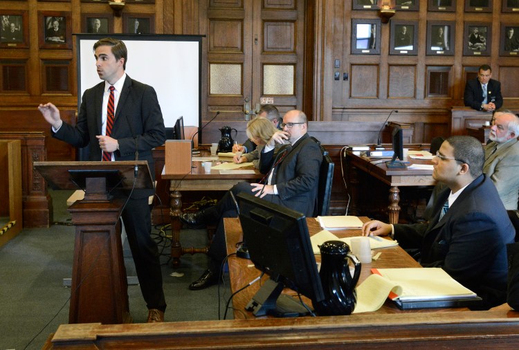 Defense attorney Dylan Boyd presents his opening statement to the jury in the murder trial of Anthony Pratt Jr., seated at lower right, at the Cumberland County Court house in Portland on Monday. Assistant Attorney General Donald Macomber listens in background.