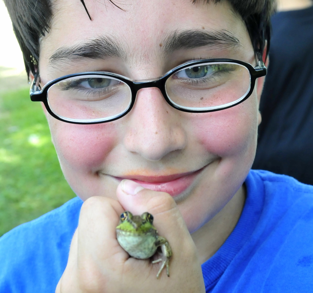 Mathew Nichols competed with his frog Speckles during the popular frog jumping contest at the Oosoola Fun Day in Norridgewock on Monday. Though Mathew did not win, he sold 11 frogs he collected over the weekend to kids who needed one for the contest. Kennebec Journal Staff Photo by David Leaming