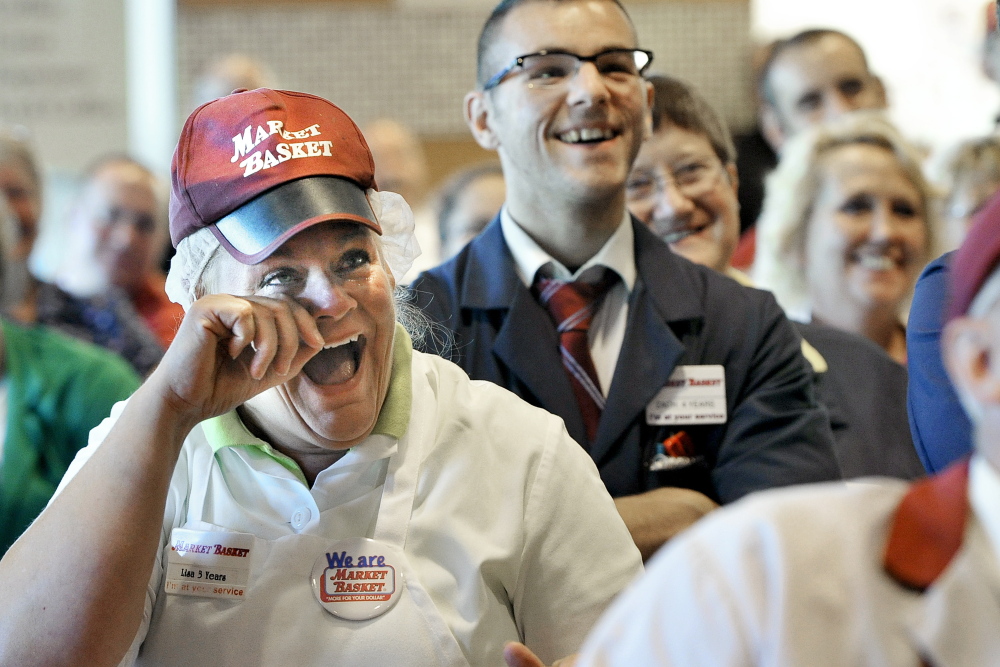Biddeford Market Basket employee Lisa Lemieux wipes away tears Thursday as she and her co-workers watch their reinstated CEO, Arthur T. Demoulas, on TV at the Biddeford store.