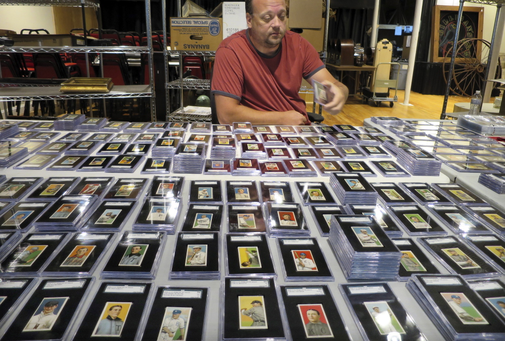 Troy Thibodeau of Saco River Auction Co. examines a collection of more than 1,400 baseball cards from 1909, 1910, and 1911 in Biddeford in September.