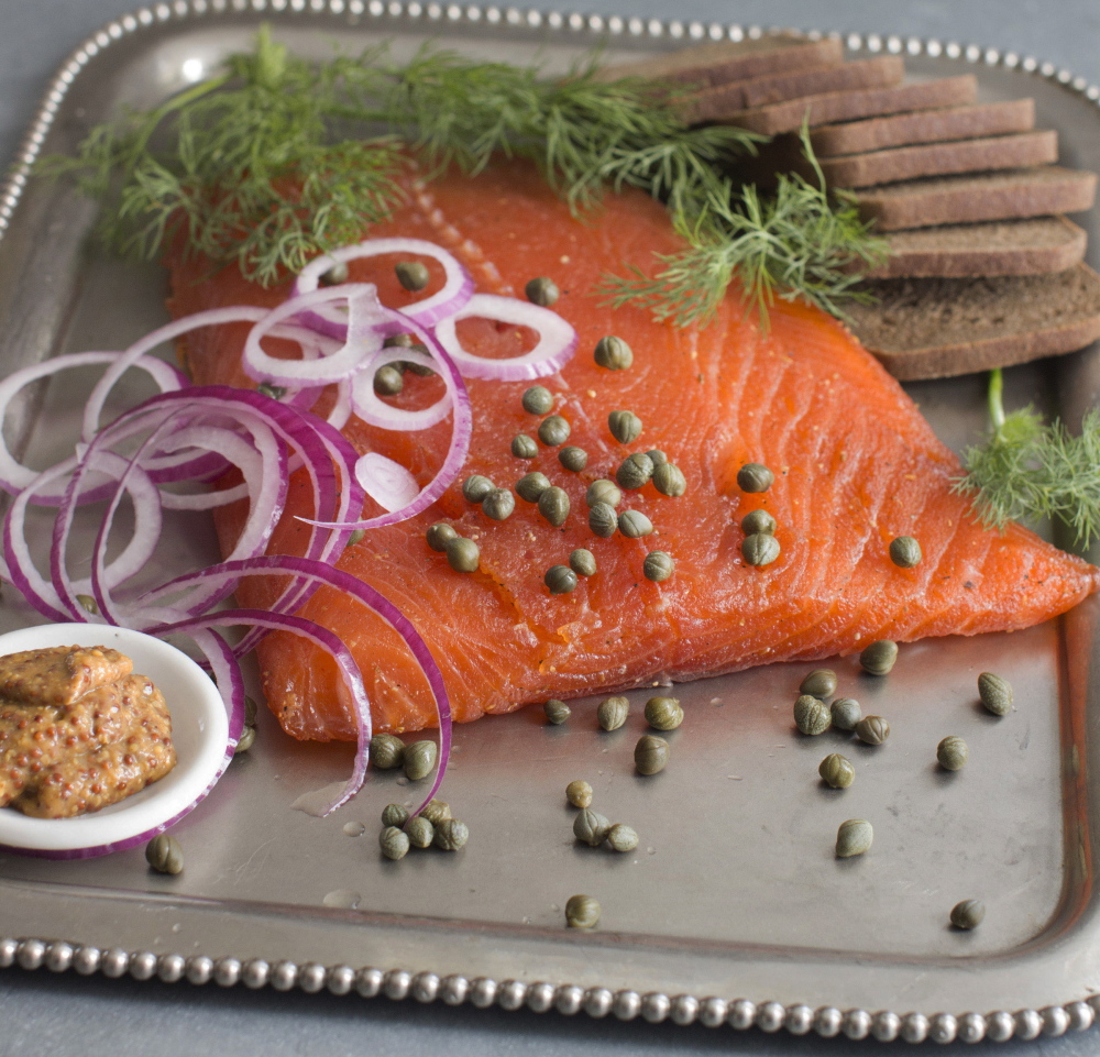 Gravlax is made by dry-curing fillets of salmon in a blend of sugar, kosher salt, fresh dill and a variety of other seasonings.