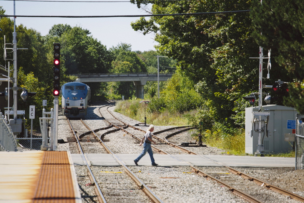 William Capistran crosses the tracks near the Brunswick train station last week. The LePage administration has taken an unusually active role in the controversy over a proposed Amtrak maintenance facility in a residential neighborhood of Brunswick.