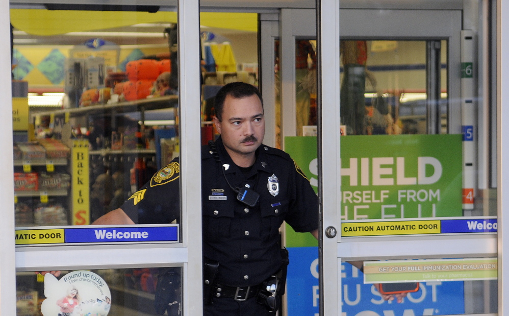 Augusta police Sgt. Vincente Morris closes the doors Tuesday at the Rite Aid pharmacy on Hospital Street in Augusta after it was robbed. Police were investigating a report of an attempted robbery at the Rite Aid on North Belfast Avenue in Augusta when the Hospital Street pharmacy was hit, according to police.