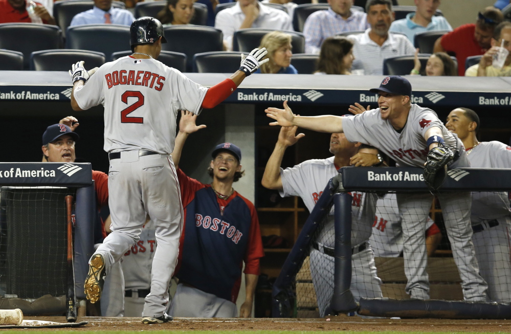 Boston’s Xander Bogaerts is greeted at the dugout steps after his third-inning solo home run off New York Yankees starting pitcher Shane Greene, moments after Boston’s Daniel Nava hit a three-run home run off Greene.