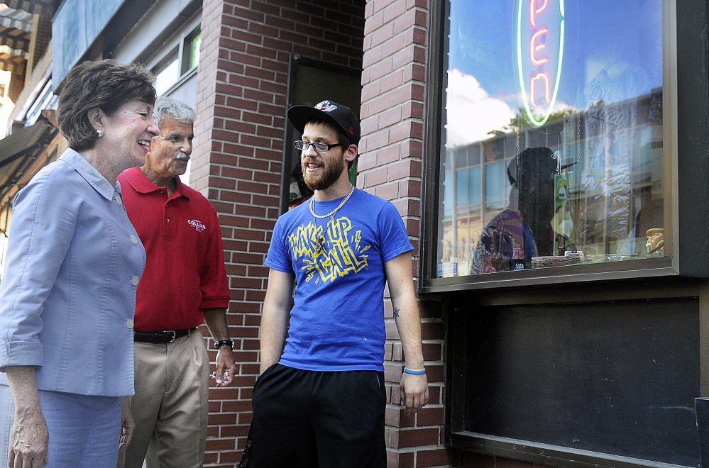 U.S. Sen. Susan Collins and state Sen. Roger Katz, R-Augusta, speak with Ralph Arbour on Wednesday outside Cosmic Charlie’s in Augusta, where Arbour works. Katz accompanied Collins on a campaign swing through the downtown.