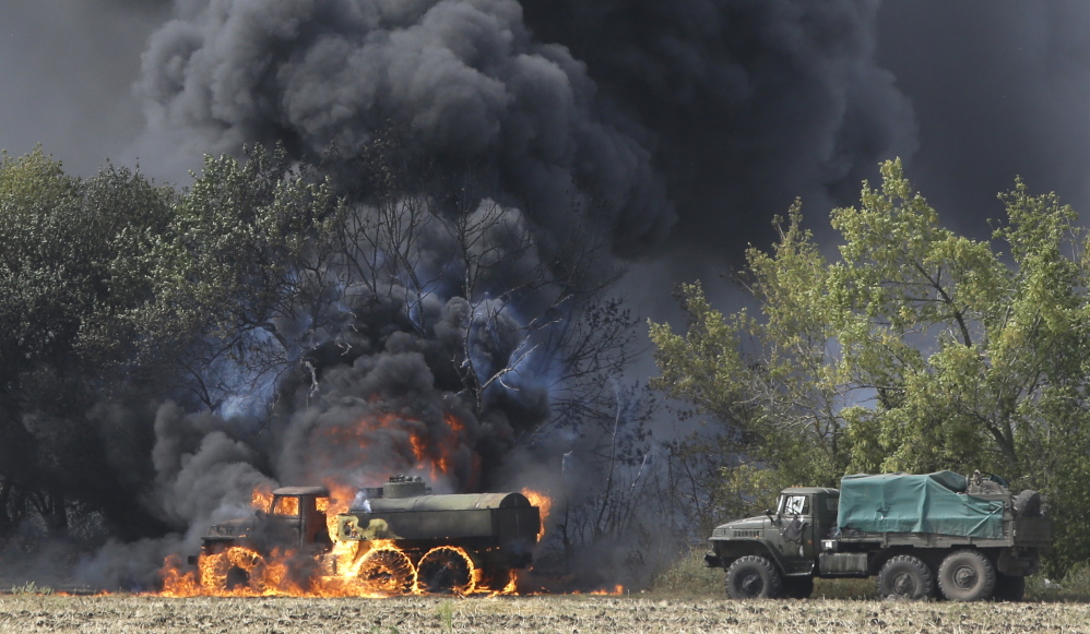 Unmarked Military vehicles burning in country roads in the village of Berezove, eastern Ukraine.