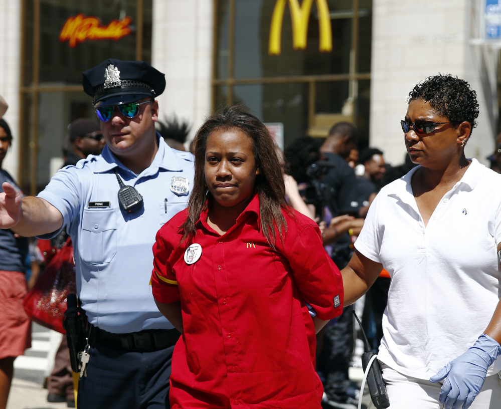 A fast-food worker is detained by police Thursday outside a McDonald’s in Philadelphia during a protest to push fast-food chains to pay their employees at least $15 an hour.