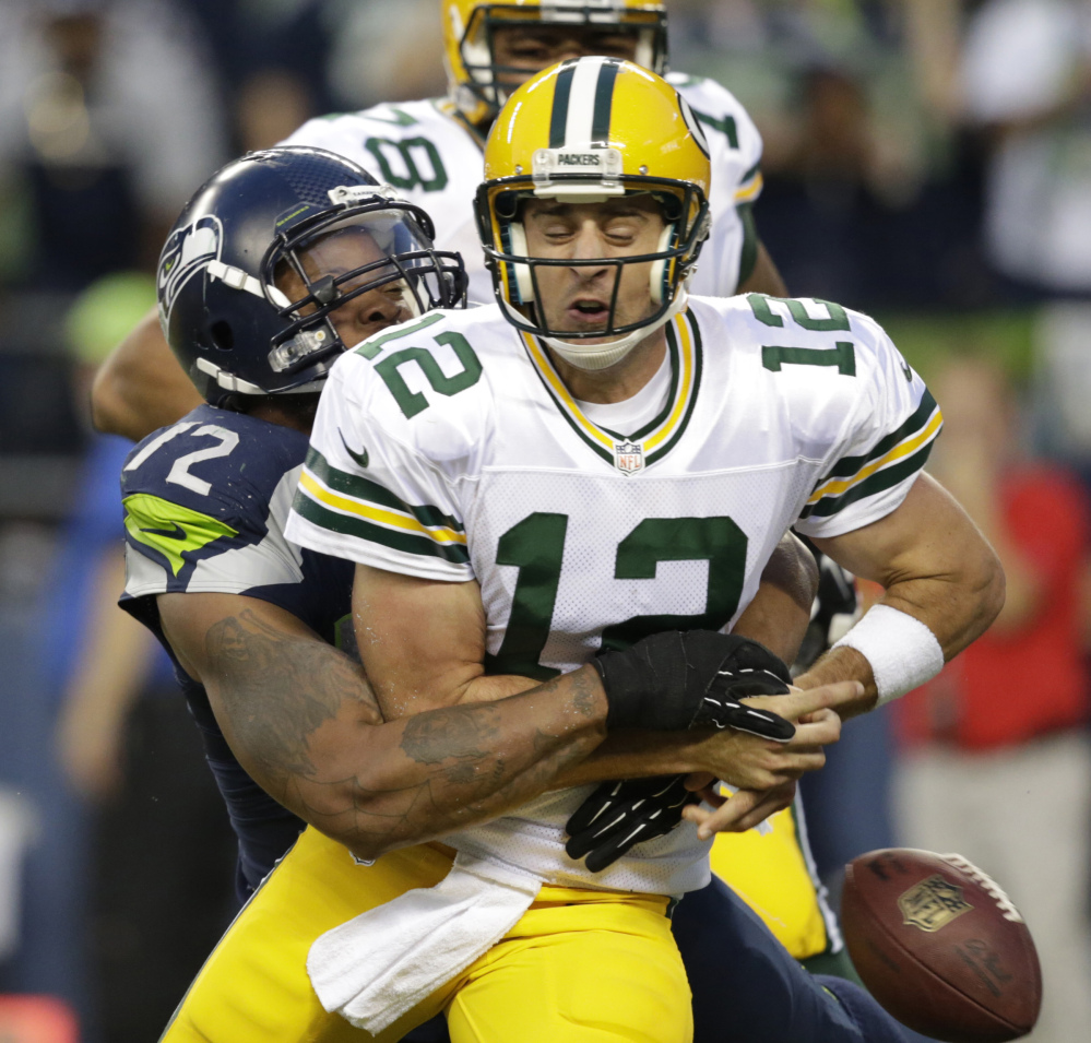 Seattle Seahawks defensive end Michael Bennett forces Green Bay Packers quarterback Aaron Rodgers to fumble in the second half Thursday in Seattle. A Packers player recovered the ball in the end zone but was tackled for a safety on the play. The Associated Press