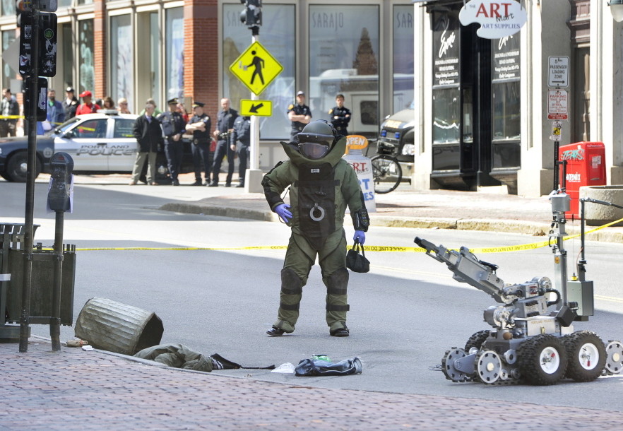 A Portland police bomb squad member uses a robot to remove a suspicious device from a trash can outside the CVS drugstore at 510 Congress St. on April 11, 2014.