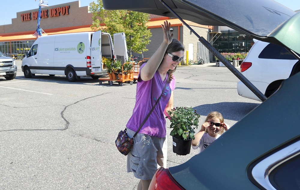 Sarah Sweeney of Portland puts the flowers she bought with her credit card into her car Friday. Gordon Chibroski/Staff Photographer