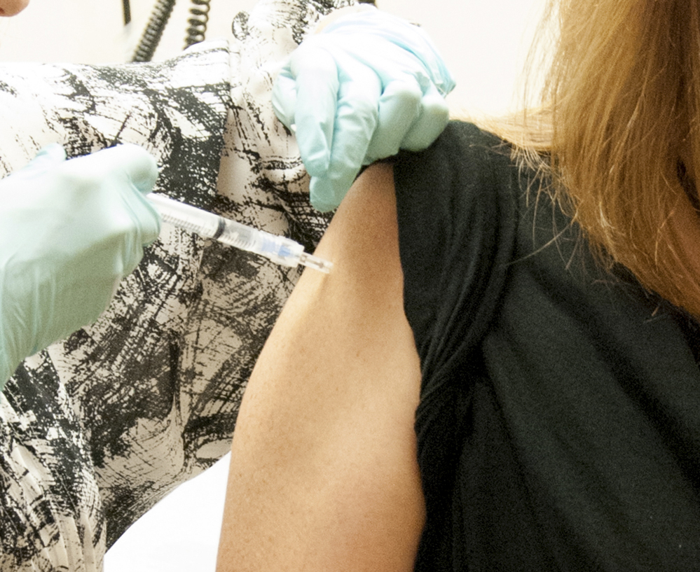 A woman receives a dose of the investigational Ebola vaccine at the NIH Clinical Center in Bethesda, Md. The WHO is backing an old-school method to combat the outbreak.