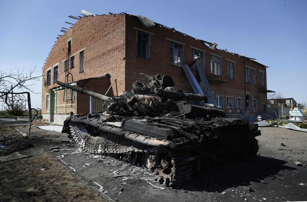 A burned Ukrainian army tank is seen near a destroyed kindergarten in the village of Kominternove, Ukraine, on Saturday.