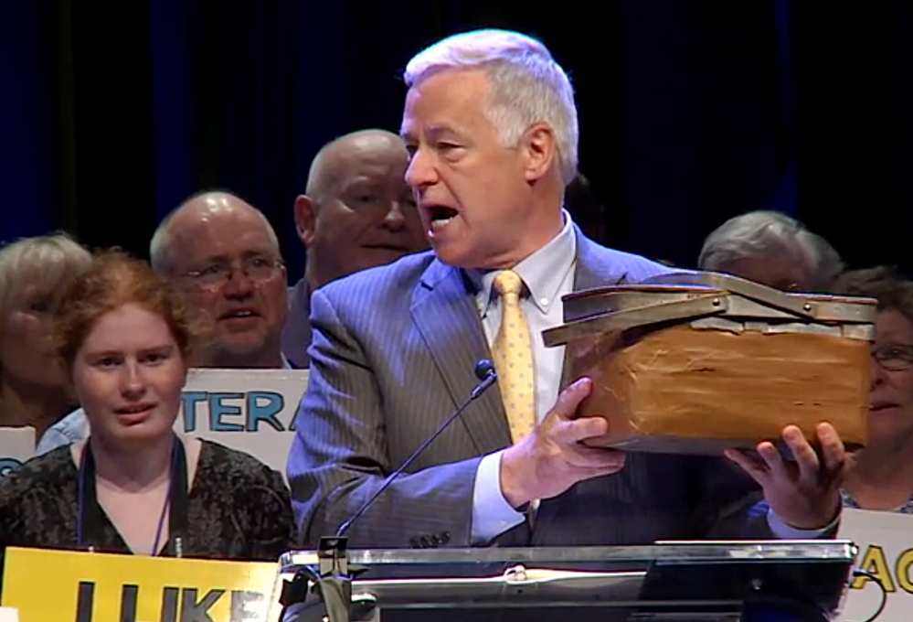 Rep. Mike Michaud holds his lunch bucket at the Democratic State Convention in Bangor last spring. He hopes to give it a new home in Augusta in January.