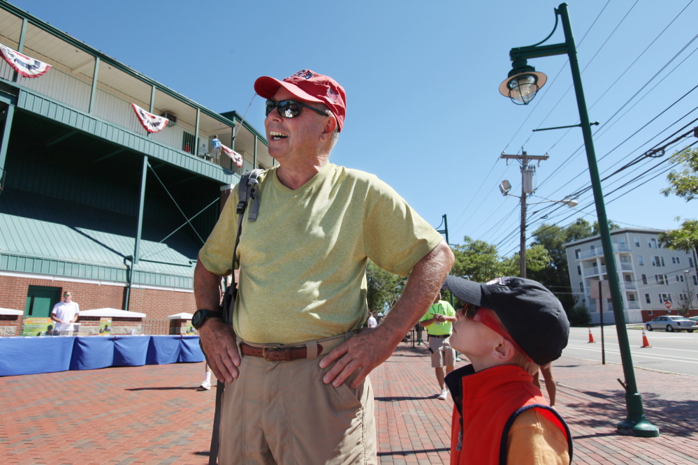Roland Moore, left, joined by grandson Benjamin Moore, speaks about his decision to miss the Patriots season opener and instead see the Sea Dogs on Sunday at Hadlock Field in Portland.